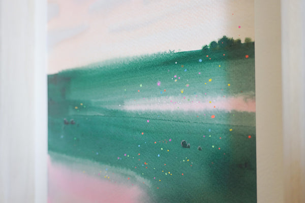 Abstract watercolour  landscape painting featuring green hills and water with delicate splatters of pink, yellow, and blue, framed by white borders on the left and right.
