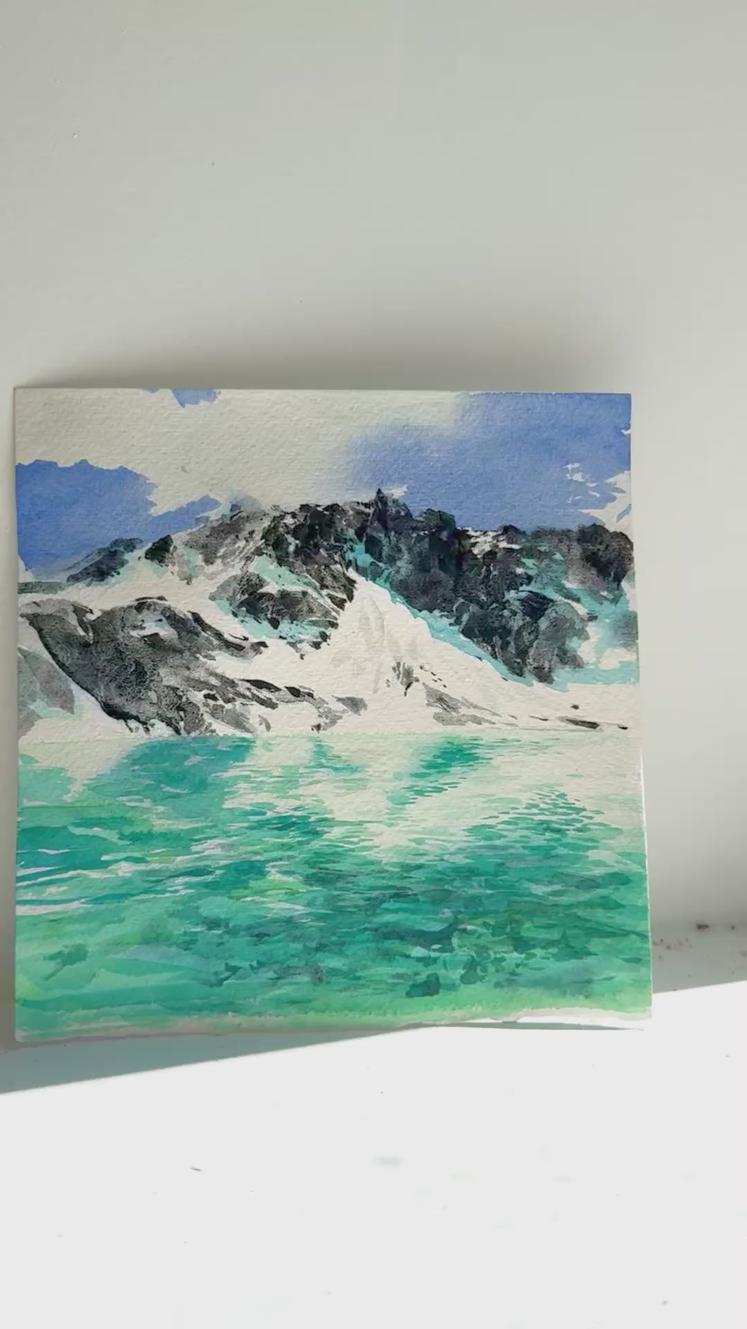 Artistic watercolour painting of Wedgemount Lake mountain landscape with water on a textured white background